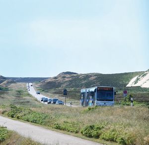 Ein blauer Bus fährt die Straße an der Wanderdüne nach List auf Sylt